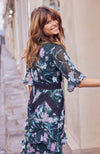 Hand-designed soft florals brush the green base in soft blues and pinks. The high cut neckline boasts statement lace trim that also covers the waist and skirt. Style down with ankle boots for day-to-day looks, or style up with heels for dressy occa