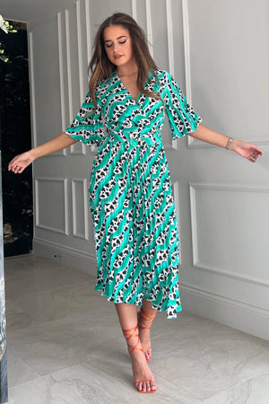 Featuring a wrap over neckline &amp; delicate pleated angel sleeves, this midi dress cinches you in at the waist with a large belt with buckle detail creating the perfect silhouette. The invisible zip fastening is perfect for easy on and the pleated midi skirt creates a soft &amp; feminine vibe.