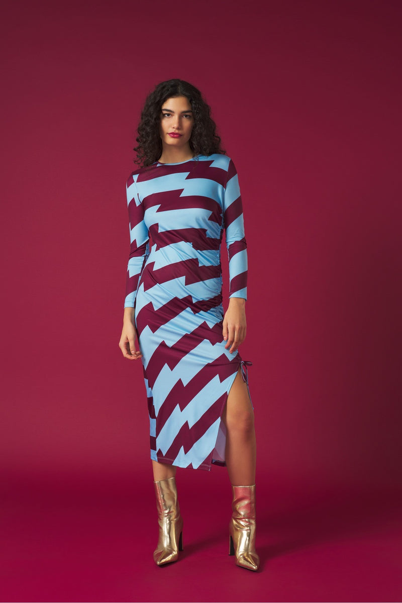 Midi dress with adjustable side gathering and shoulder pads. Long sleeves and round neck. Side vent. Back fastening with button.