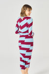 Midi dress with adjustable side gathering and shoulder pads. Long sleeves and round neck. Side vent. Back fastening with button.