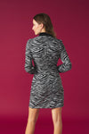Collar dress with long sleeves and cuffs with button. Skirt with draped detail and wrap front. Back zip fastening.