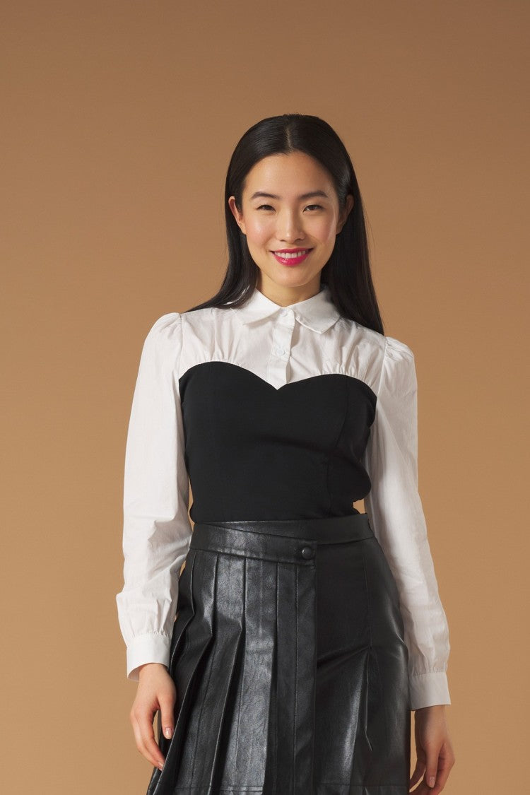 Combined shirt with long sleeves. Contrast fabric detail on the body. Front button fastening and side zip.