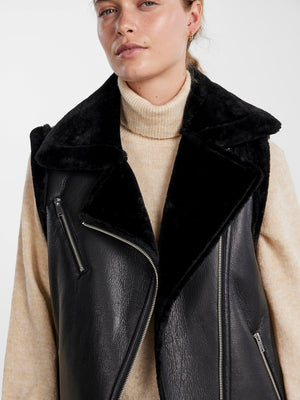 - Faux leather gilet - Asymmetric zip-up front - Oversized faux fur lapel - Sleeveless design with faux fur trim - Zipped chest pocket - Zipped side pockets