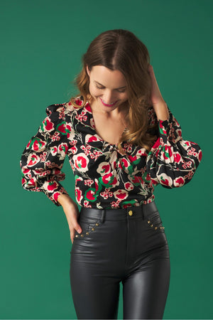V-neck top with puff sleeves. Knot detail in the neck. Back zip fastening.