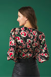 V-neck top with puff sleeves. Knot detail in the neck. Back zip fastening.