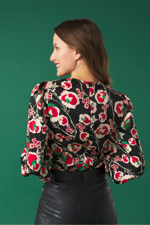 V-neck top with puff sleeves. Knot detail in the neck. Back zip fastening.