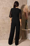 Handcrafted floral embellishments cover the sleeve, bust and leg, with flutter sleeves and plunge neckline creating a beautiful silhouette. The trouser is cut in a flattering wide leg finish, ending at floor length, and hidden hook and eye detail on the neckline allows for the plunge to be adjusted as desired