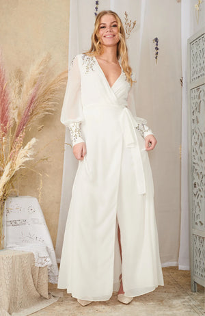 Hand designed embroidery decorates the soft ivory base with delicate details garnishing the shoulders, back and sleeves. The wrap design, plunge neckline and blouson sleeves create a beautiful silhouette that emanates romance.