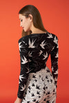 V-neck bodysuit with long sleeves and shoulder pads. Gathered detail on the front.  Model is 180 cm and wears size S.