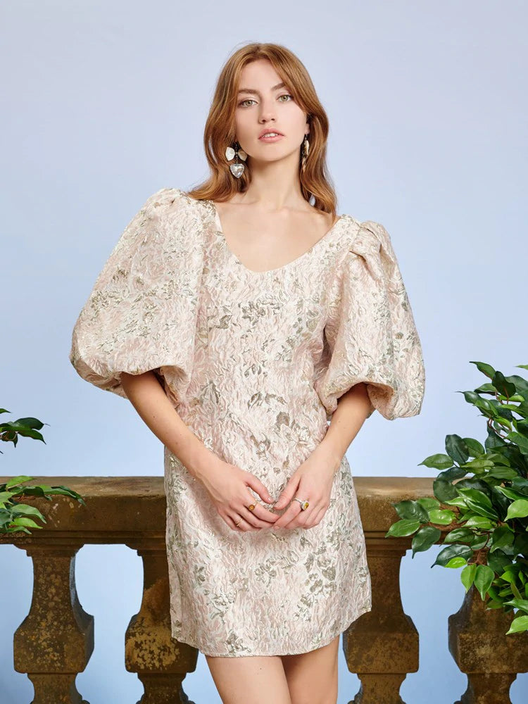 Mini dress in a floral metallic jacquard fabric. A fitted style with a low scooped neckline and oversized puff sleeves. Lined in a soft touch fabric.