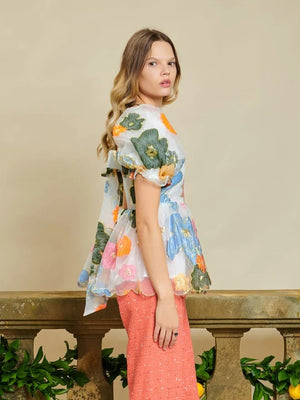 Sister Jane DREAM Primula Postcard Scallop Top. Open back top in a bright floral organza jacquard fabric. Featuring a scallop edge neckline and hem with short puff sleeves. Adjustable ties bow at the back. Fully lined in a soft touch fabric